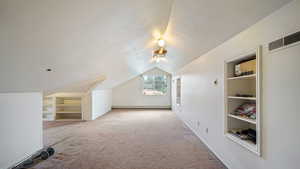Bonus loft room featuring built in shelves, carpet flooring, a textured ceiling, and baseboard heating