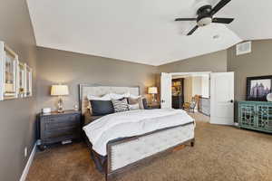 Carpeted bedroom with lofted ceiling and ceiling fan