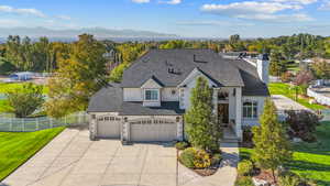 French provincial home with stucco siding, a mountain view, roof with shingles, and concrete driveway