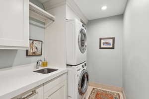 Laundry area with stacked washer and clothes dryer and cabinet space