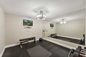 Exercise area featuring baseboards and dark rubber floors