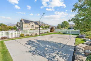 View of basketball court featuring a residential view, a mountain view, and basketball hoop