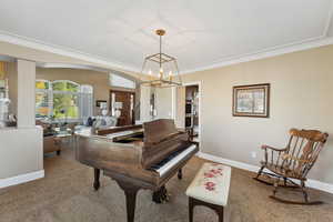 Living area featuring arched walkways, a chandelier, carpet, and ornamental molding