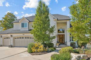 View of front of home with roof with shingles, driveway, an attached garage, and stucco siding