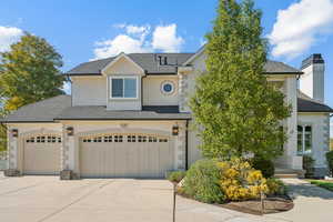 View of front of home featuring concrete driveway, stucco siding, roof with shingles, stone siding, and a garage