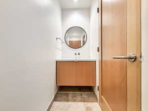 Bathroom with vanity and light stone finish flooring