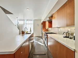 Kitchen with high end appliances, a large island, and light countertops