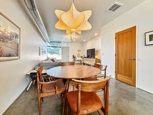Dining area featuring finished concrete flooring and recessed lighting