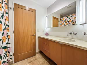 Bathroom featuring vanity, a shower with curtain, and light tile patterned flooring