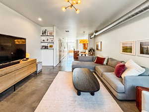 Living room featuring concrete floors and hanging lights