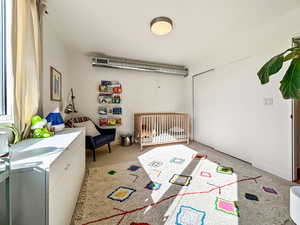 Bedroom featuring a crib and a closet