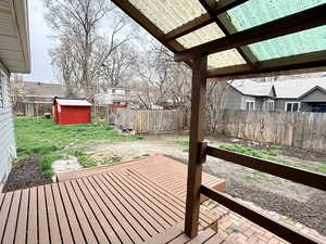 Deck with a fenced backyard and a shed