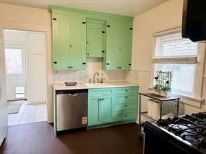 Kitchen with green cabinets, healthy amount of natural light, stainless steel dishwasher, and black gas range oven