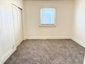Unfurnished bedroom featuring carpet flooring and a closet