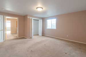 Unfurnished bedroom featuring light carpet and a closet