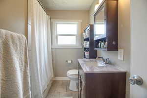 Full bath featuring vanity, a shower with curtain, and light tile patterned flooring