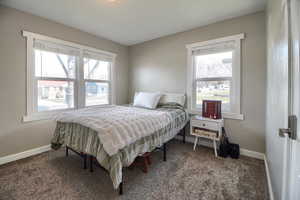 Bedroom with dark carpet and baseboards
