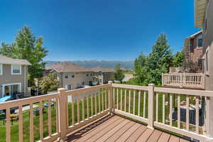 Deck with a residential view, a lawn, and a mountain view