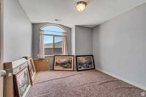 Spare room featuring carpet and baseboards