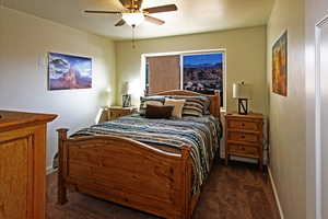 Bedroom with dark colored carpet and ceiling fan