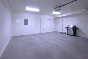 Garage featuring electric panel and a garage door opener