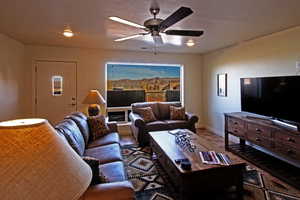 Living area featuring baseboards and ceiling fan