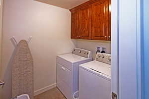 Laundry room featuring cabinet space and washer and clothes dryer