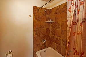 Bathroom with shower / bathtub combination with curtain