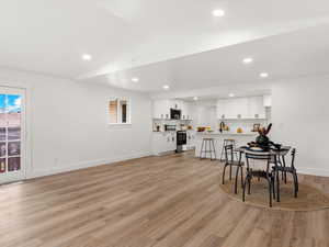 Dining space featuring vaulted ceiling, light wood-style floors, and recessed lighting