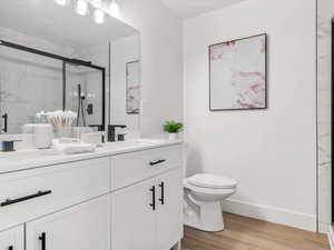Master Bathroom featuring double vanity, light wood finished floors, and a marble finish shower