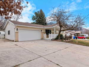 Ranch-style home with concrete driveway, an attached garage, a porch, and brick siding