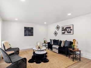 Living area featuring light wood finished floors and recessed lighting