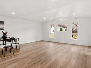 Unfurnished living room with light wood-style flooring, vaulted ceiling, and recessed lighting