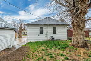 Rear view of house featuring roof with shingles and a patio area