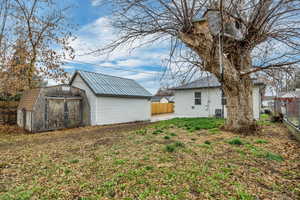 Fenced backyard featuring a patio area and a storage shed