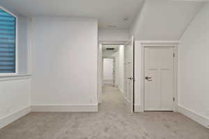 Unfurnished bedroom featuring light carpet and baseboards