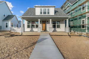Bungalow-style home featuring covered porch and roof with shingles