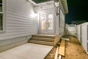 Exterior entry at twilight featuring a gate and french doors