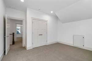 Additional living space featuring light carpet and recessed lighting