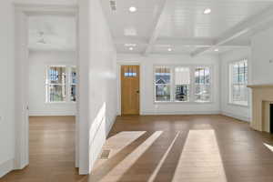 Entrance foyer featuring recessed lighting, beamed ceiling, light wood-style flooring, healthy amount of natural light, and a fireplace