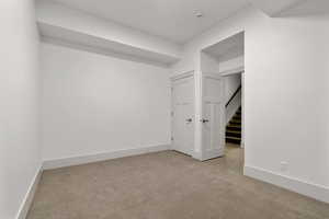 Spare room with light carpet and baseboards