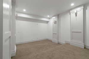 Finished below grade area featuring light carpet and recessed lighting