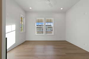 Spare room with wood-type flooring, ceiling fan, and recessed lighting