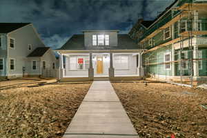 View of front of home with a porch and a shingled roof