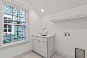 Laundry area with hookup for a washing machine, vaulted ceiling, cabinet space, and recessed lighting