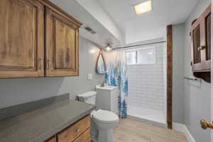 Full bath featuring vanity, a shower stall, and wood finish floors