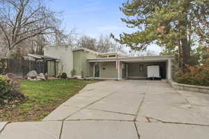 Mid-century inspired home featuring an attached carport and driveway