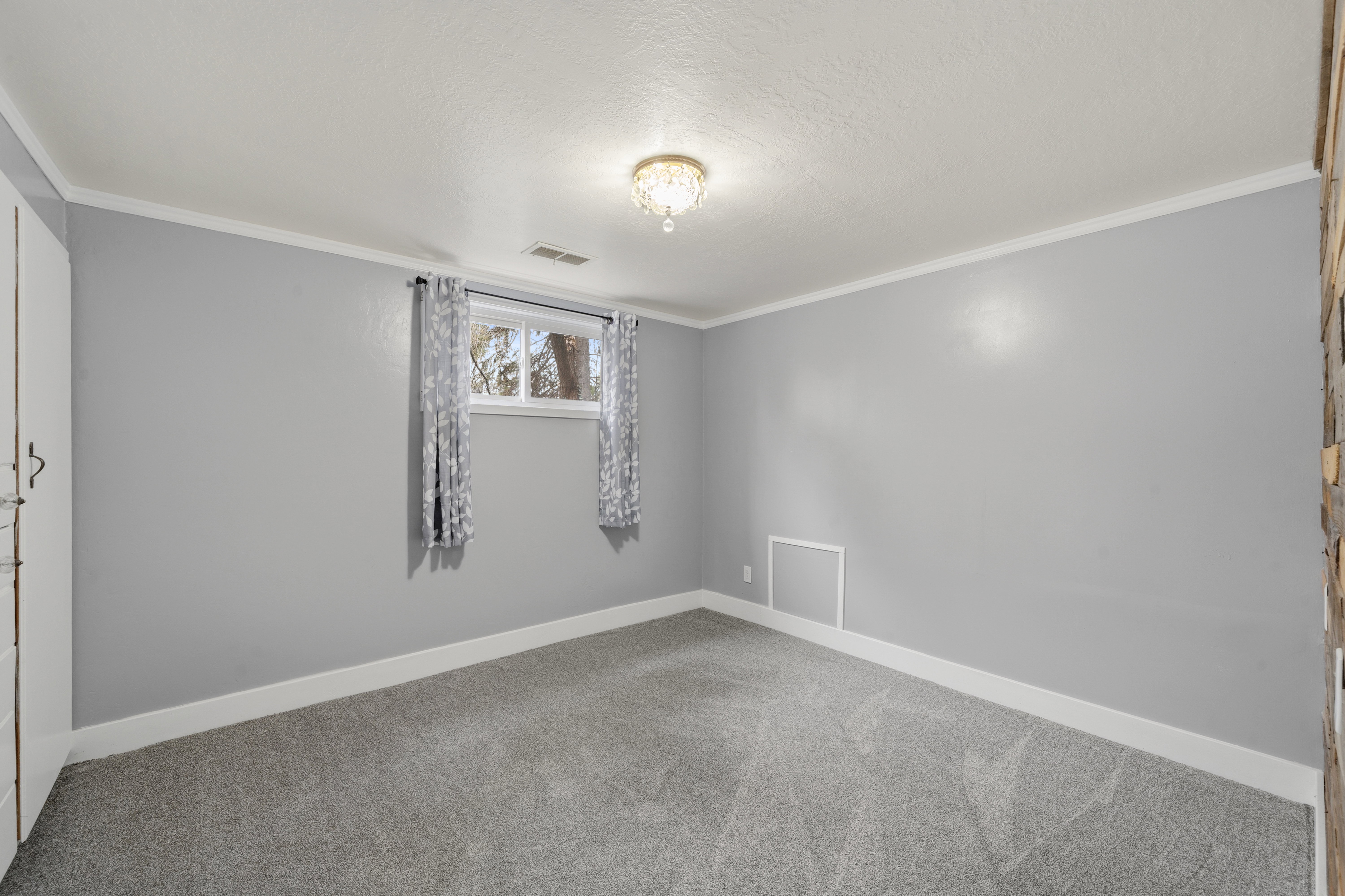 Spare room featuring ornamental molding and light colored carpet