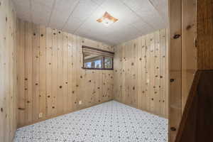 Empty room with tile patterned floors and wooden walls