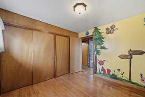 Unfurnished bedroom featuring light wood-type flooring and a closet